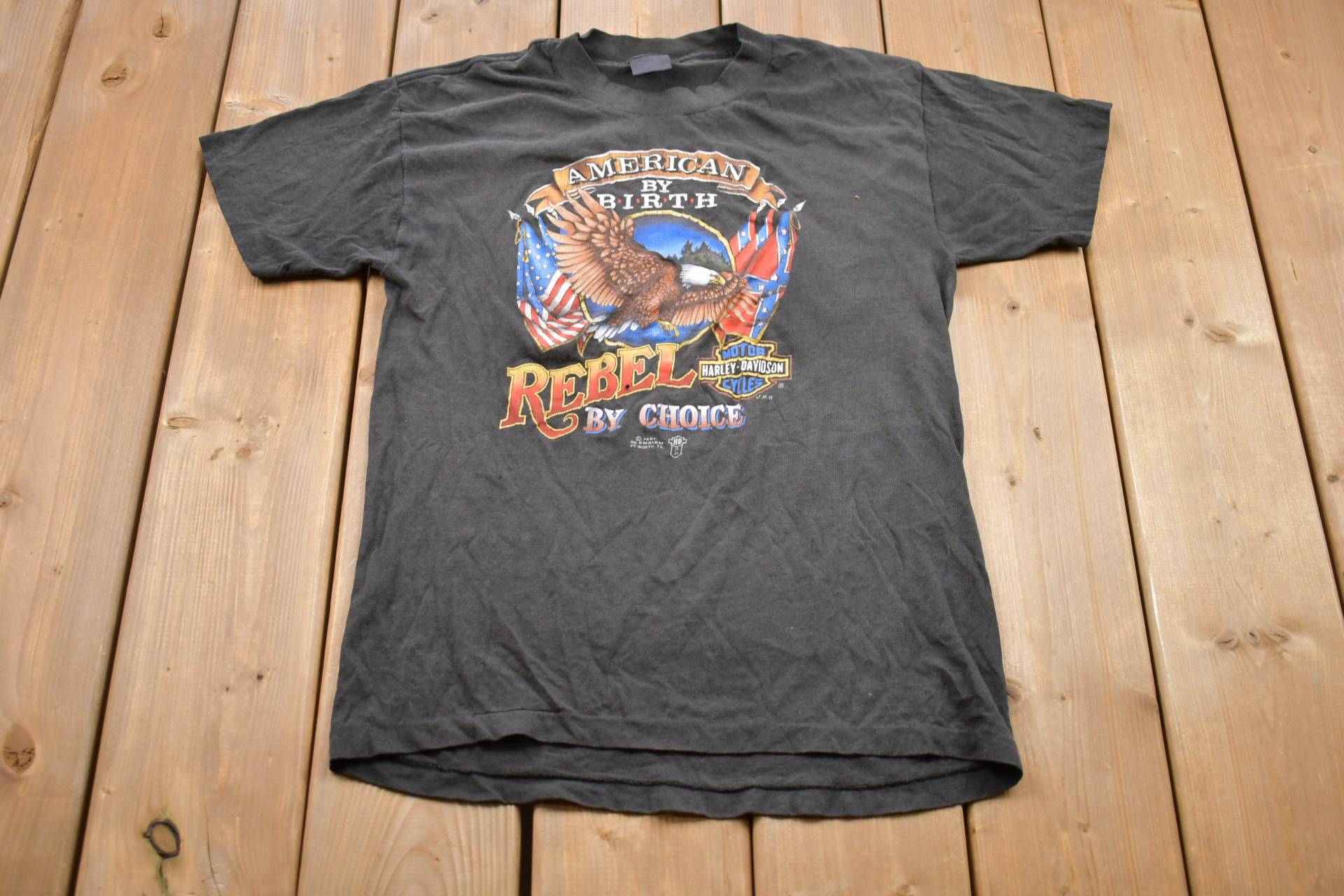 Vintage 1987 Rebel By Wahl Harley Davidson Motorcycles Graphic T-Shirt/80Er Jahre Grafik Biker Streetwear Fashion 3D Emblem Vintage 1987 Rebel By Wahl Harley Davidson Motorcycles Graphic T-Shirt/80Er Jahre Grafik Biker Streetwear Fashion 3D Emblem von Lostboysvintage