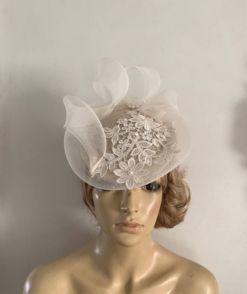 Elfenbeinfarbene Kintabmütze Mit Spitzenapplikör Und Skulpturalen Crin Detail Verziert von LouizaMillinery