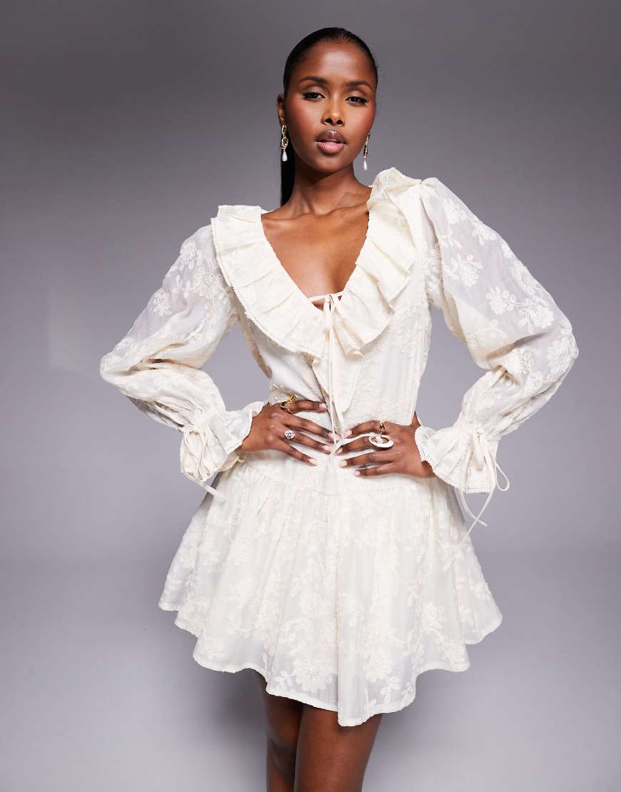 Love Triangle - Spitzen-Minikleid in Vintage-Creme mit tiefer Taille und Rüschendetails-Weiß Love Triangle - Spitzen-Minikleid in Vintage-Creme mit tiefer Taille und Rüschendetails-Weiß von Love Triangle