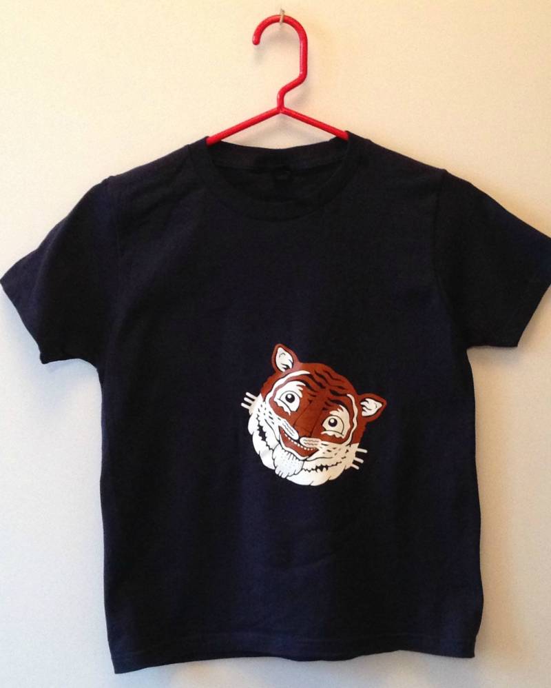 Orange Und Weißer Tiger Auf Einem Weichen Marineblauen T-Shirt Aus 100% Ringgesponnener Baumwolle Orange Und Weißer Tiger Auf Einem Weichen Marineblauen T-Shirt Aus 100% Ringgesponnener Baumwolle von Mackrelmint