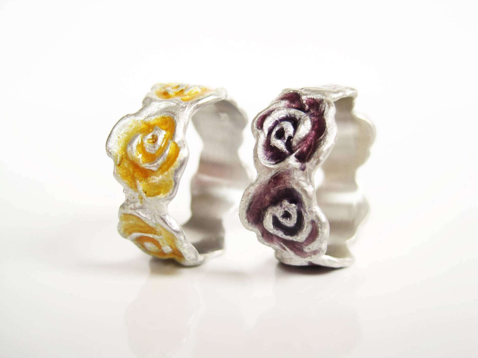 Rosenring, Ein Rosenband Mit Sechs Blüten Umrundet Den Finger, Silber Violett Oder Goldgelb Emailliert, Von Iris Schamberger Märchenschmuck von Maerchenschmuck