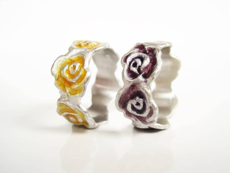 Rosenring, Ein Rosenband Mit Sechs Blüten Umrundet Den Finger, Silber Violett Oder Goldgelb Emailliert, Von Iris Schamberger Märchenschmuck von Maerchenschmuck