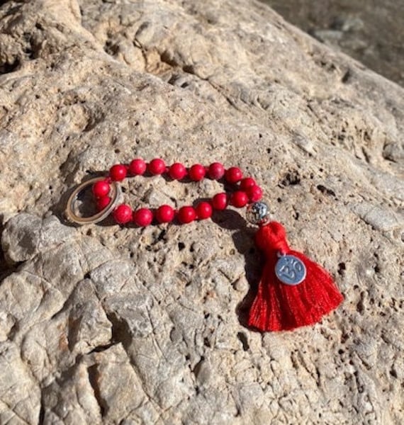 Schlüsselanhänger - Mini Mala "Magnesit" Mit Hämatit-Lavaperle Und Kleiner Om Münze An Roter Baumwollquaste Schlüsselanhänger - Mini Mala "Magnesit" Mit Hämatit-Lavaperle Und Kleiner Om Münze An Roter Baumwollquaste von MamalaDesign