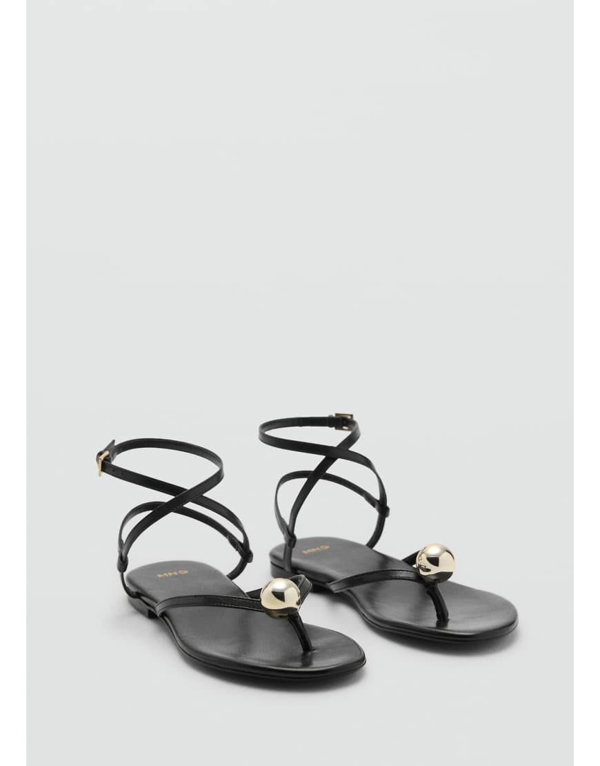 Mango featuring Kaia Gerber - Flache Sandalen in Schwarz mit überkreuzten Riemchen von Mango