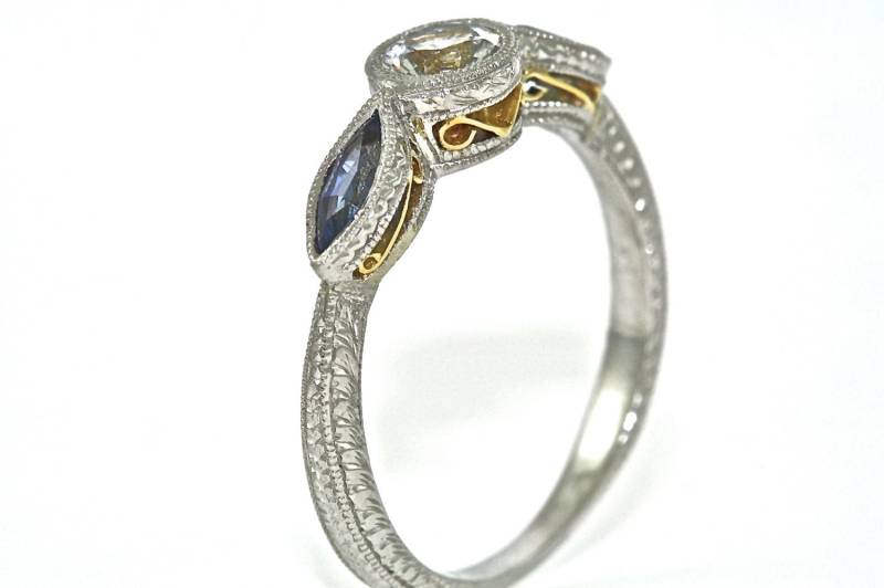 Platin Und 18Kt Gelbe Gold 3 Stein Gravierte Engagement Hand Ring Mit 2 Blaue Saphire Einer .55Ct Weißen Saphir-Mitte von MasterPieceJewelers