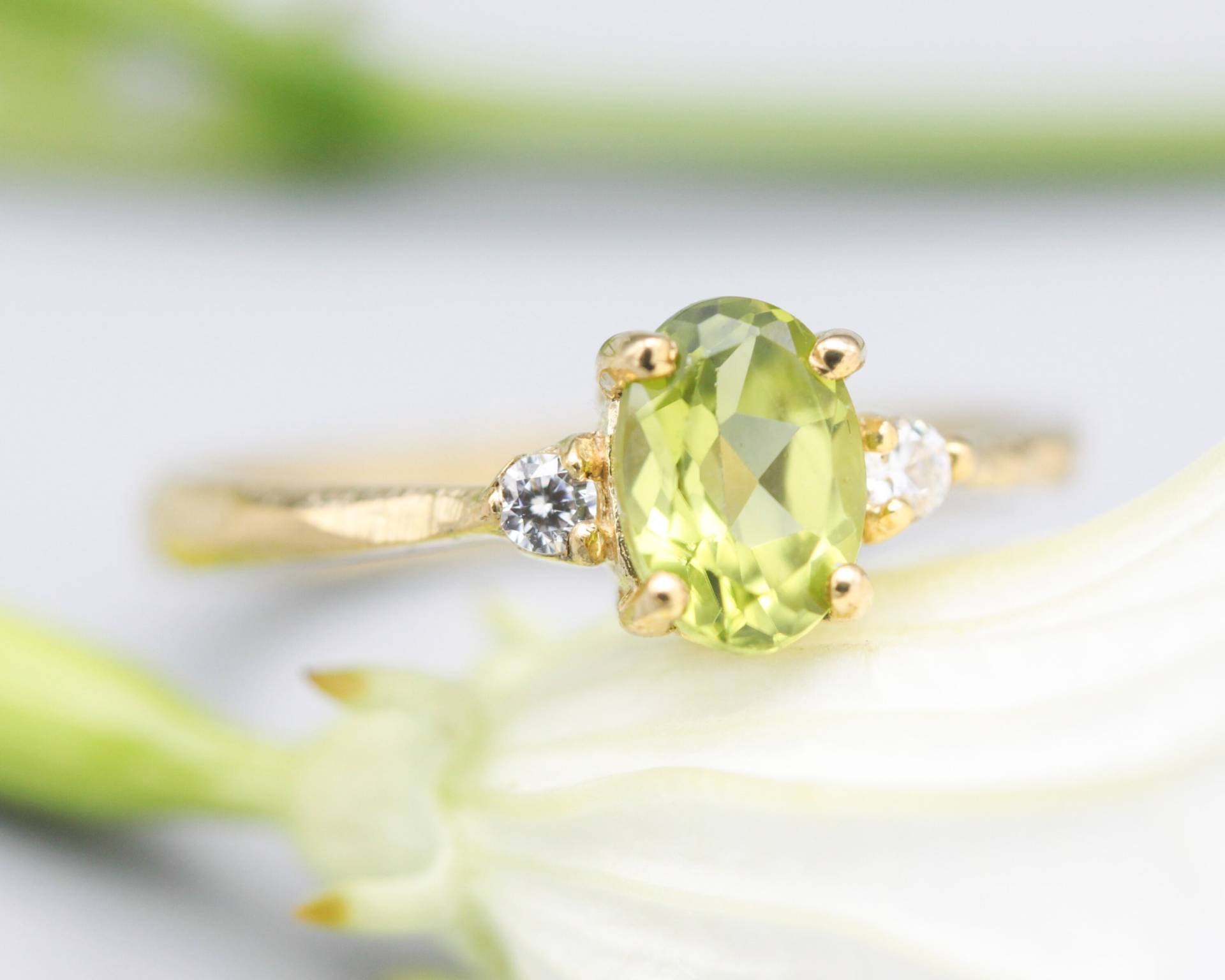 Ovaler Facettierter Peridot Ring Mit Winzigen Runden Diamanten Seitlich Gesetzt Edelsteine in Krappenfassung 14K Goldtexturband von MetalStudioJewelry