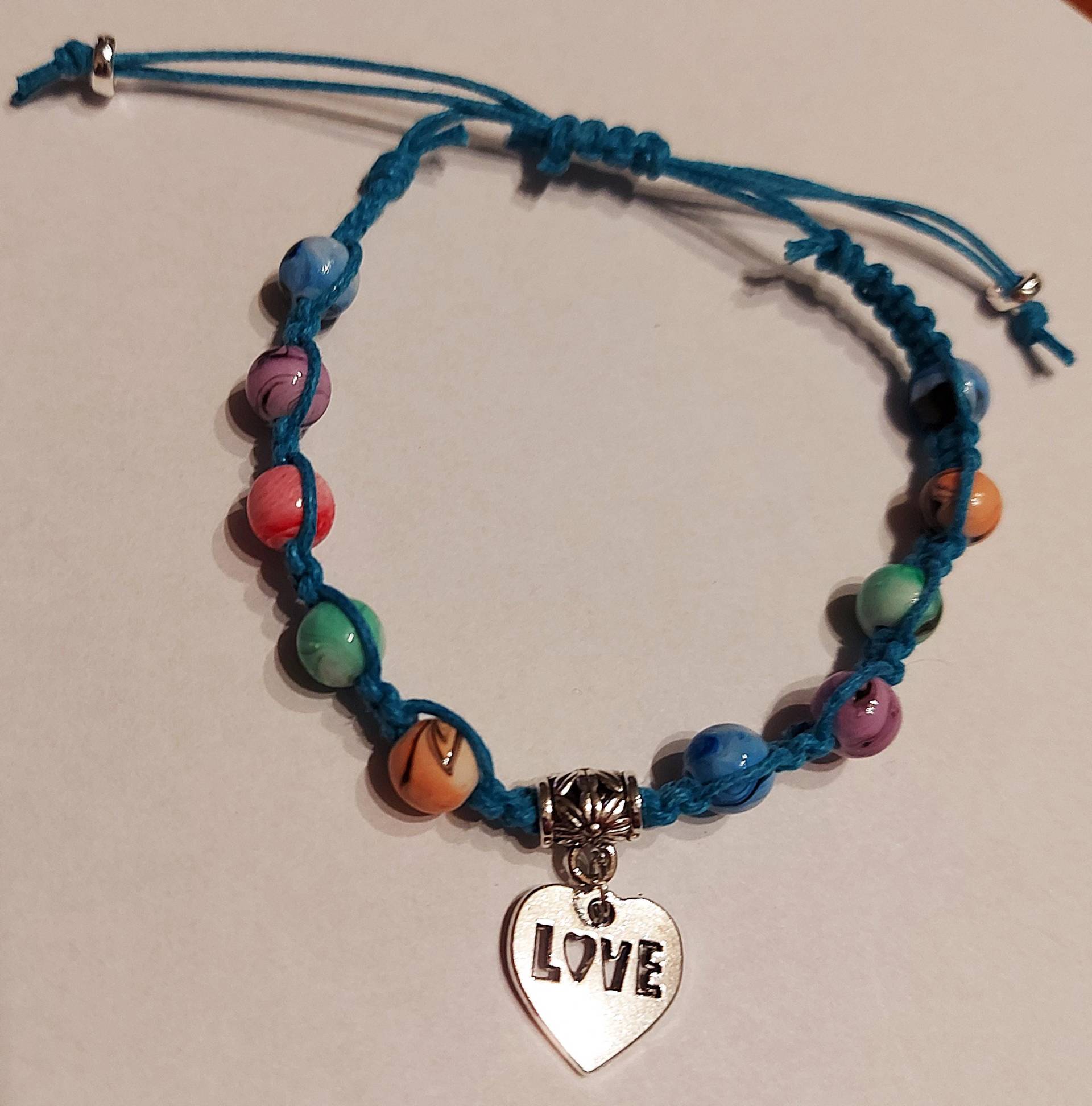 Handgefertigtes Blaues Makramee-Armband 18-27 cm Mit Tintenmusterperlen Und Love-Anhänger Handgefertigtes Blaues Makramee-Armband 18-27 cm Mit Tintenmusterperlen Und Love-Anhänger von MichisWollbox