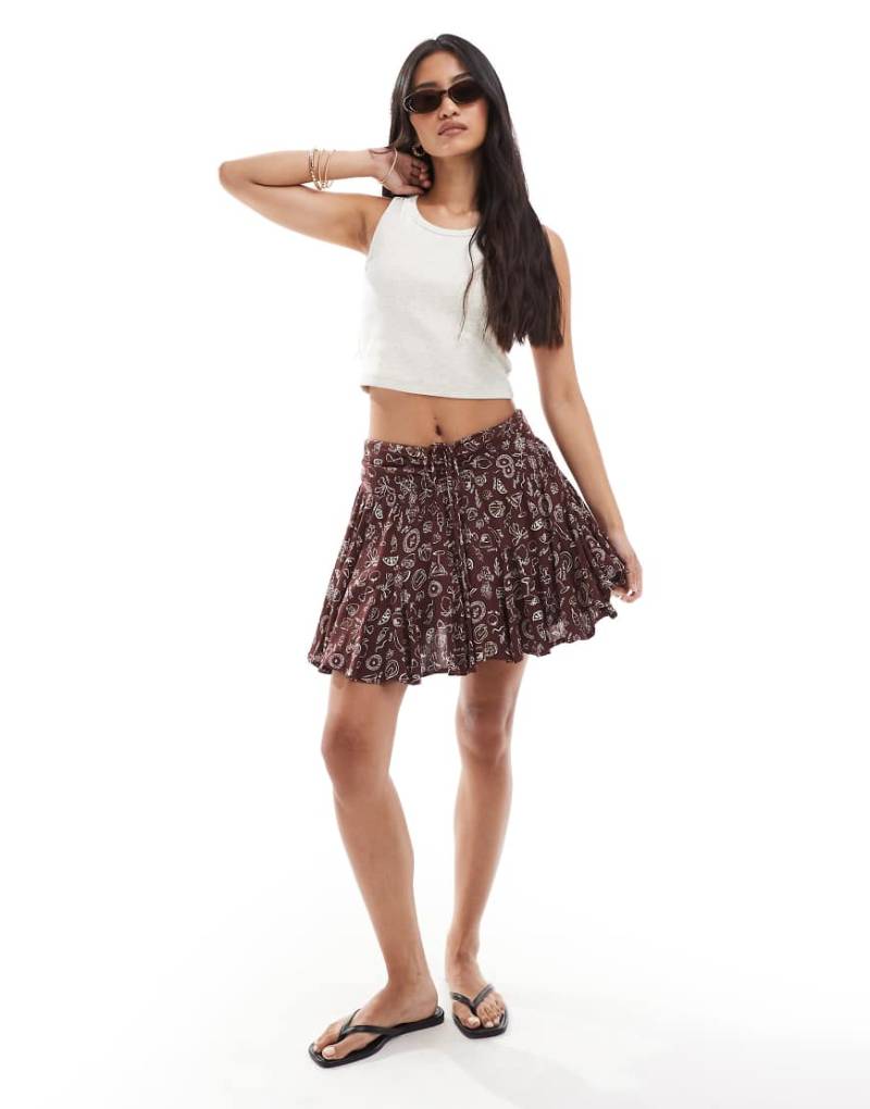 Miss Selfridge - Schwingende Shorts aus Mullstoff in Braun mit Urlaubsprints von Miss Selfridge