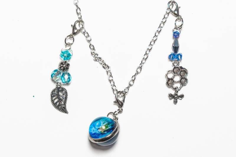 Die Erde. Ein Kleiner, Runder Anhänger Indem Sich Ein Bild Der Erde Befindet. Zusätzlich Zwei Kleine Aus Kristallglasperlen von MksbDigitalArtist