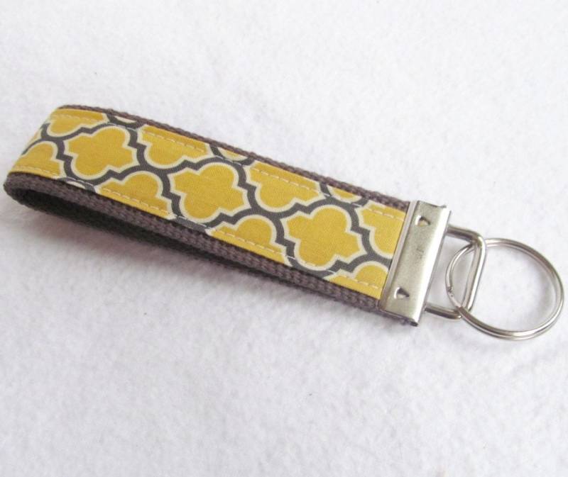 Schlüsselanhänger Voliere Ii Mit Gittermuster in Vintage Gelb Auf Anthrazitfarbenem Gurtband von MomNMiaDesigns