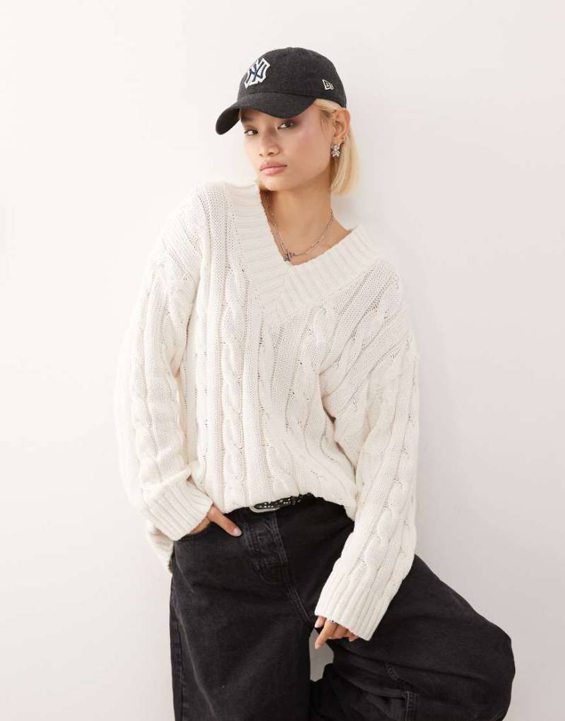 Monki - Dicker Oversize-Strickpullover in Wollweiß mit V-Ausschnitt und Zopfmuster Monki - Dicker Oversize-Strickpullover in Wollweiß mit V-Ausschnitt und Zopfmuster von Monki