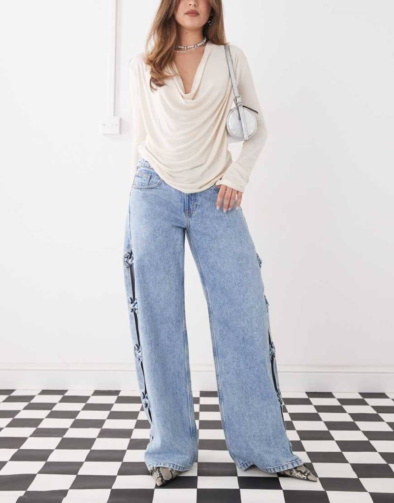 Monki - Imoo - Weit geschnittene Jeans in hellblauer Waschung mit niedrigem Bund und Cut-Out mit Schleifendetails von Monki