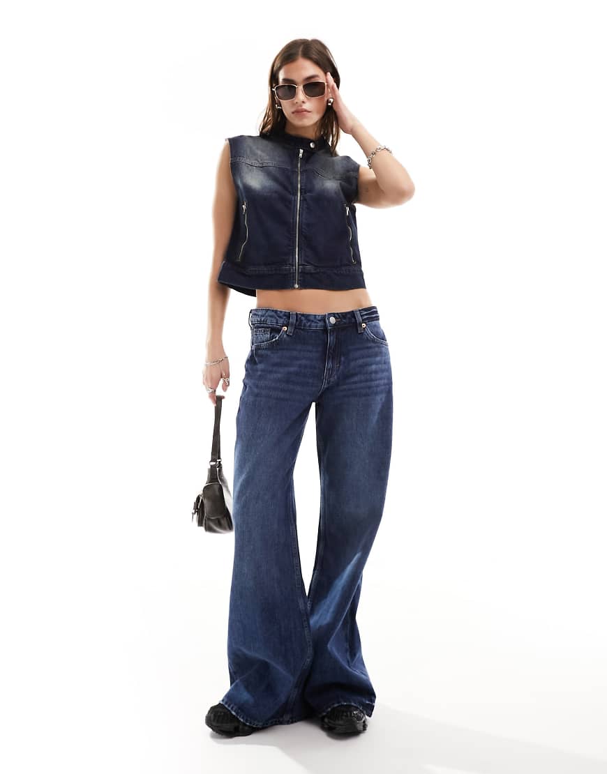 Monki - Kiri - Locker geschnittene Schlagjeans in dunkelblauer Waschung mit niedrigem Bund Monki - Kiri - Locker geschnittene Schlagjeans in dunkelblauer Waschung mit niedrigem Bund von Monki
