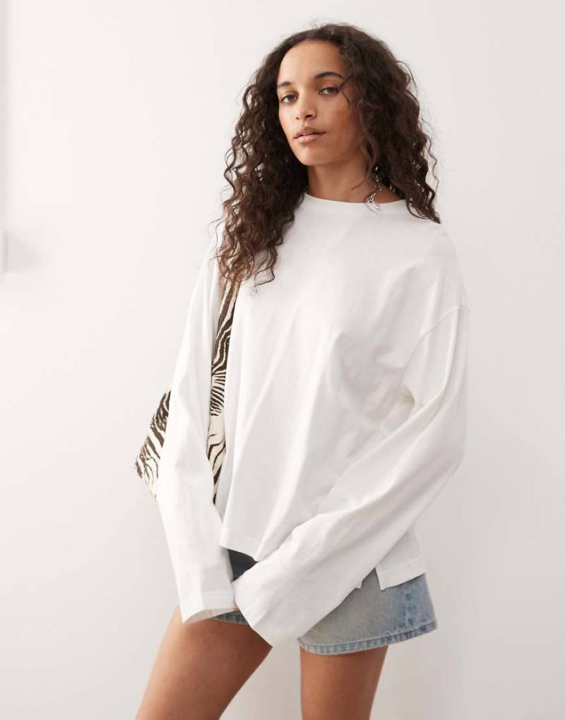 Monki - Langärmliges Oversize-T-Shirt in Weiß mit Seitenschlitzen Monki - Langärmliges Oversize-T-Shirt in Weiß mit Seitenschlitzen von Monki
