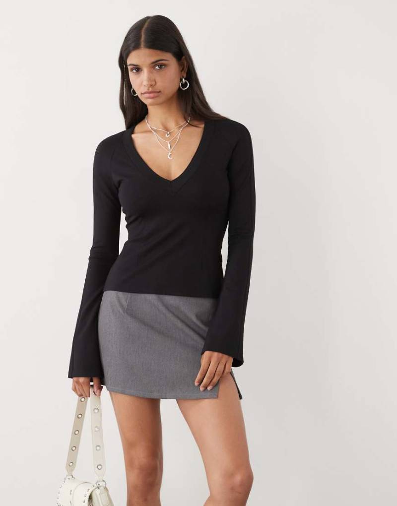 Monki - Langärmliges T-Shirt in Schwarz mit V-Ausschnitt, Trompetenärmeln und Einsatz-Details von Monki