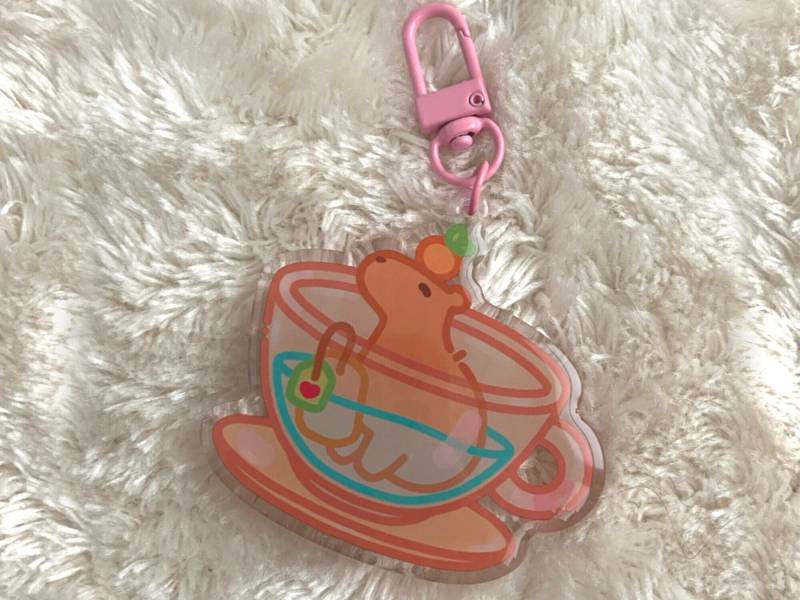 Cute Keychain Cozy Capybara in A Tea -Kawaii Acryl Charm Epoxy - Holographic Gift Keyring Accessoires Oranges Capy Art Tea Time von Moonbia