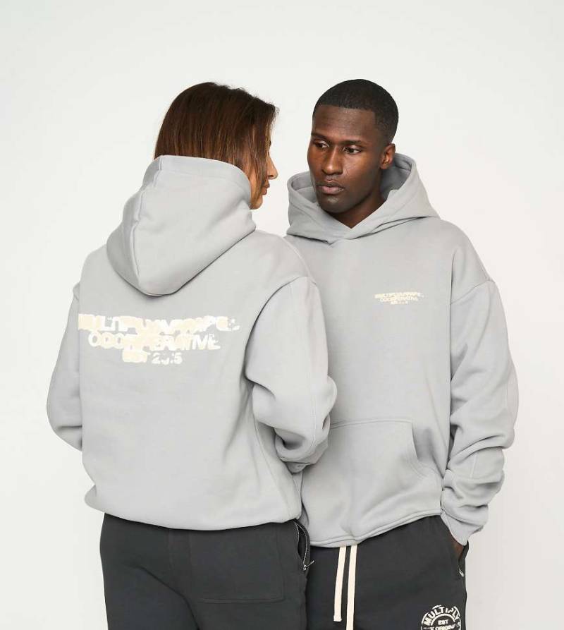 Multiply Apparel - Oversize-Kapuzenpullover in der Farbe Ultimate-Grau mit „Cooperative"-Print von Multiply Apparel