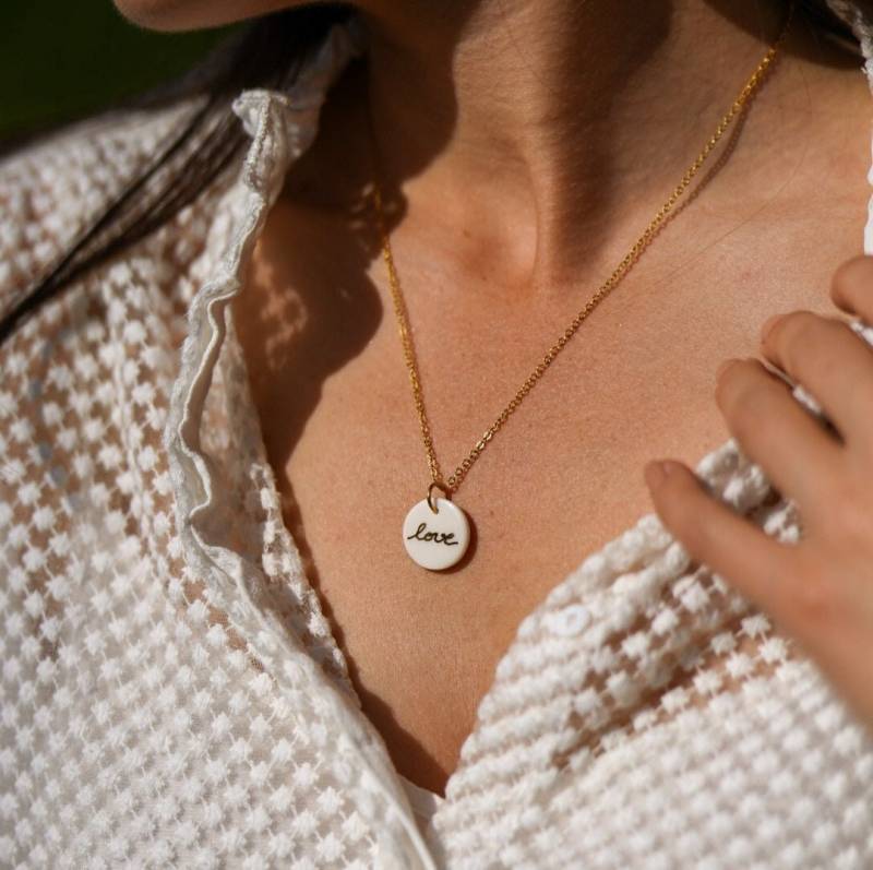 Halskette Mit Rundem Porzellananhänger Und Dem in Gold Geschriebenen Wort „Love" von NathaliePendersCeram