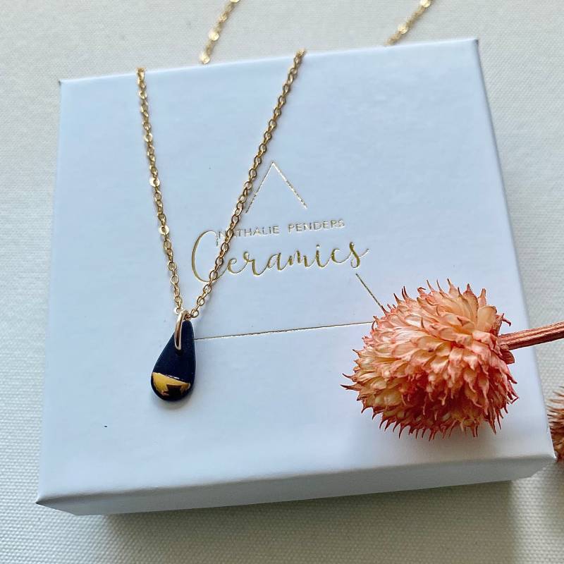 Kettenhalskette Mit Einem Schwarz-Goldenen Porzellan-Tropfenanhänger von NathaliePendersCeram