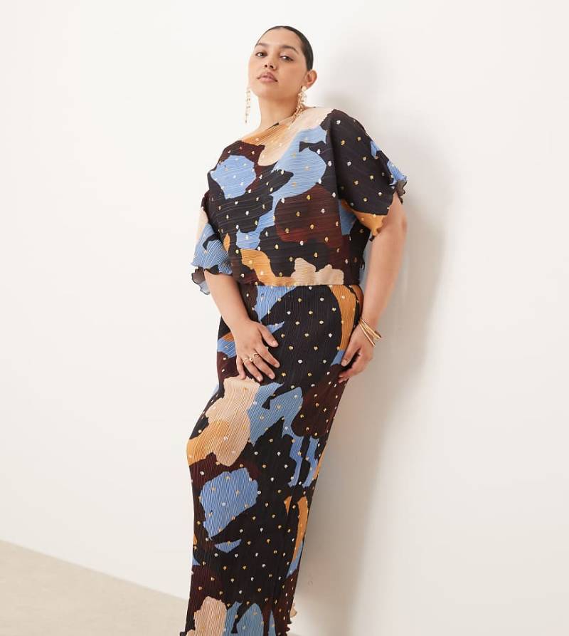 Never Fully Dressed Plus - Tilly - Plissiertes Maxikleid in Schokobraun mit asymmetrischem Schnitt und goldfarbenen Punkten in Folienoptik-Brown von Never Fully Dressed Plus