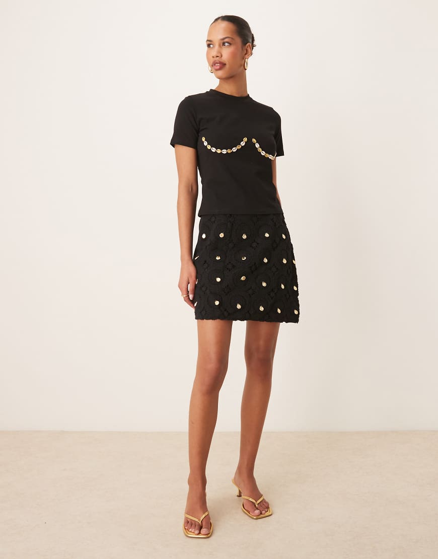 Never Fully Dressed - Gehäkelter Mini-Wickelrock in Schwarz mit Muscheldetails, Kombiteil Never Fully Dressed - Gehäkelter Mini-Wickelrock in Schwarz mit Muscheldetails, Kombiteil von Never Fully Dressed