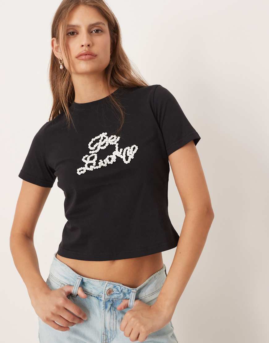 Never Fully Dressed - Knapp geschnittenes T-Shirt in Schwarz mit „Be Lucky"-Perlenapplikation von Never Fully Dressed