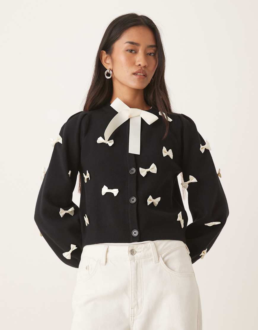 Never Fully Dressed - Strickjacke in Schwaz mit Kontrast-Zierschleifen-Schwarz Never Fully Dressed - Strickjacke in Schwaz mit Kontrast-Zierschleifen-Schwarz von Never Fully Dressed