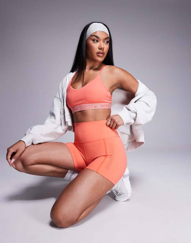 Nike Training - Gym Life Swoosh Indy Dri-FIT - Sport-BH in Koralle mit leichter Stützkraft-Rosa von Nike Training