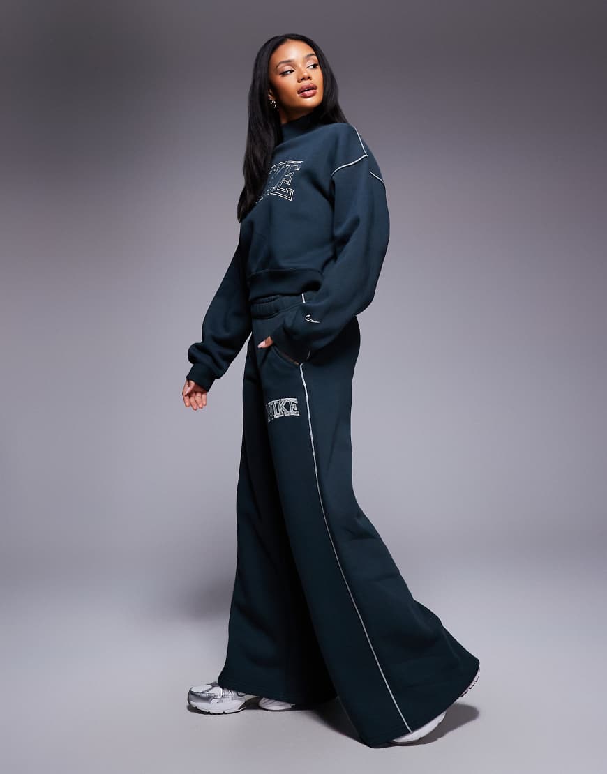 Nike - Jogginghose in Dunkelgrün mit weitem Bein und Retro-Logo von Nike