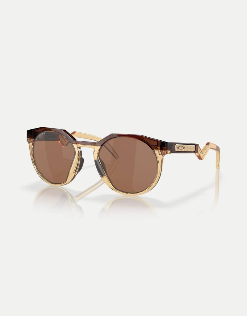 Oakley - Kylian Mbappé Signature Series HSTN - Runde Sonnenbrille in Braun mit verspiegelten Gläsern in dunklem Bernsteinbraun/hellem Curry von Oakley
