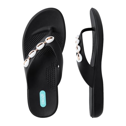 Oka-B Damen Elle Lanie Flip Flop Sandale mit Kaurimuschel-Charms, Lakritze, 5-6 Oka-B Damen Elle Lanie Flip Flop Sandale mit Kaurimuschel-Charms, Lakritze, 5-6 von Oka-B