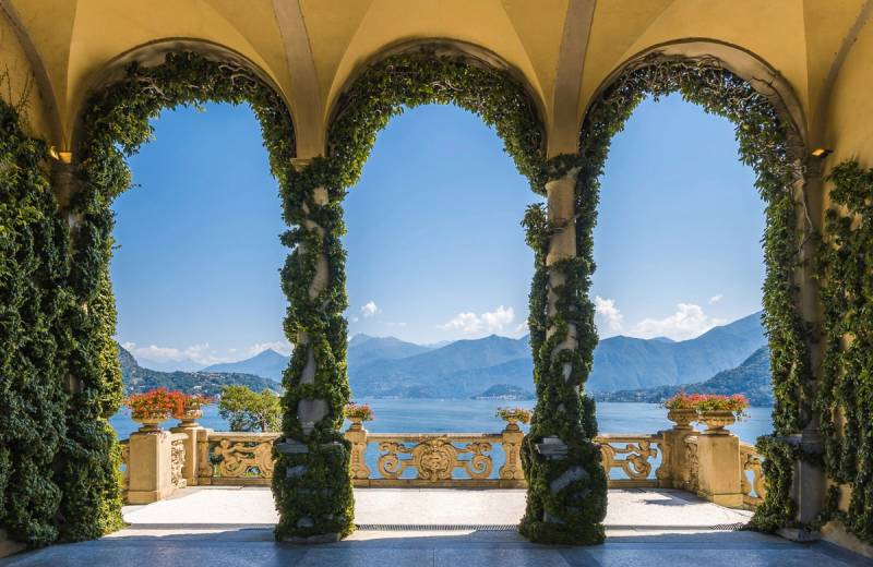 Papermoon Fototapete "TERRASSE-SÄULEN LANDSCHAFT GEBIRGE BLUMEN NATUR MEER" von Papermoon