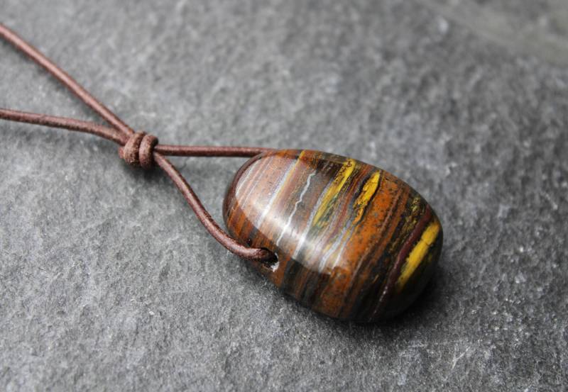 Tigereisen Anhänger Gebohrter Trommelstein Am Lederband Mit Schiebeschließe Edelsteinkette Heilstein Geschenk Accessoire Für Sie Und Ihn von PerlentanzBerlin