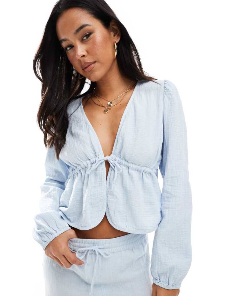 Pieces - Cropped Bluse aus gekräuselter Baumwolle in Hellblau mit gebundener Vorderseite, Kombiteil Pieces - Cropped Bluse aus gekräuselter Baumwolle in Hellblau mit gebundener Vorderseite, Kombiteil von Pieces