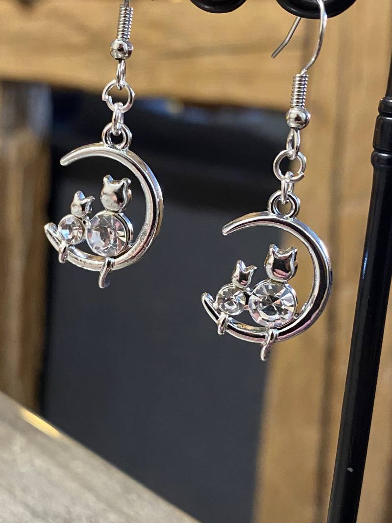 Silberne Duo-Ohrringe Einer Kleinen Katze Aus Metall Und Strasssteinen Auf Dem Mond von PierresetPlume