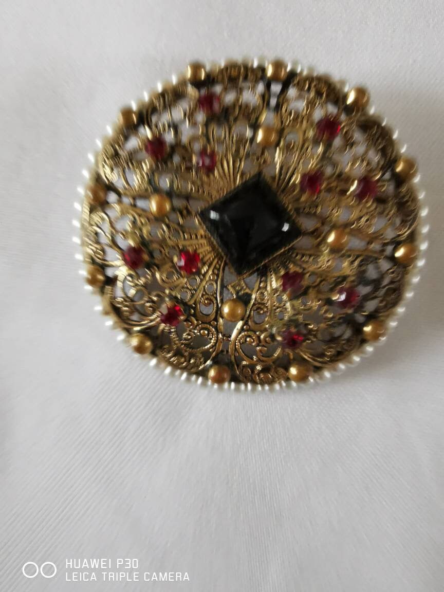 Eine Wunderschön Detaillierte Filagree Style Brosche. Rote Steine Und Perlen Surround Eine Wunderschön Detaillierte Filagree Style Brosche. Rote Steine Und Perlen Surround von Pollyvintagera