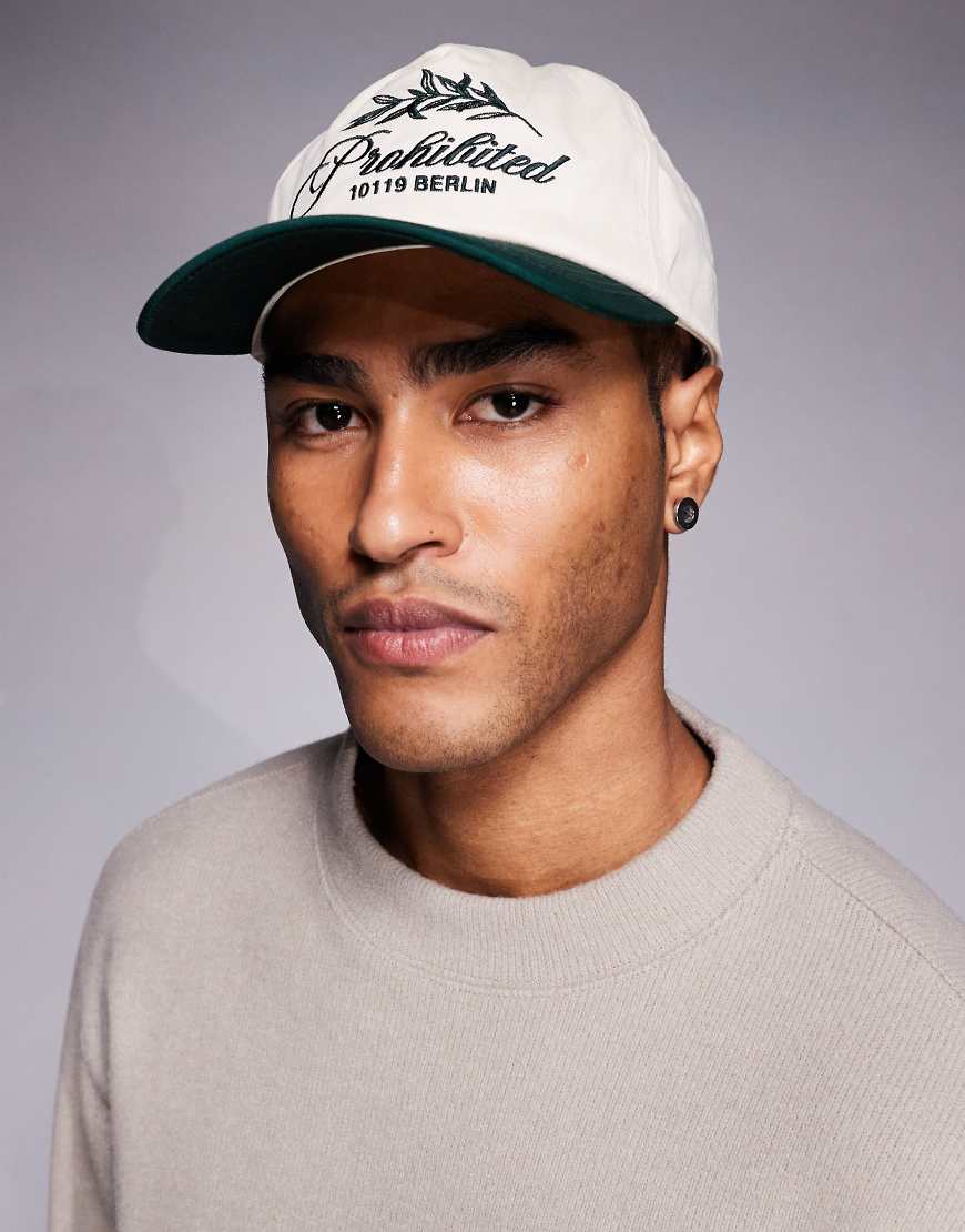 Prohibited - Kappe in Cremeweiß mit kontrastierendem Schirm in Grün und Blatt-Logo von Prohibited