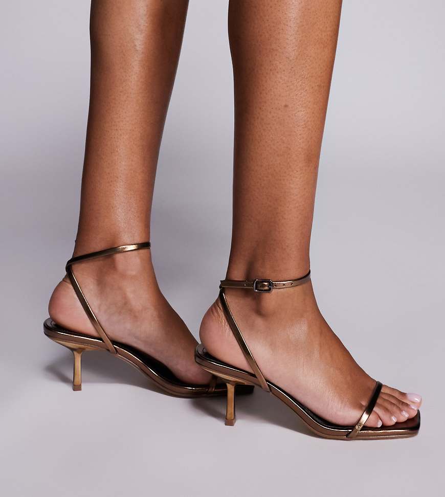 Public Desire Wide Fit - Natalya - Minimalistische Sandalen in Bronze mit Kitten-Absatz, weite Passform-Brown Public Desire Wide Fit - Natalya - Minimalistische Sandalen in Bronze mit Kitten-Absatz, weite Passform-Brown von Public Desire Wide Fit