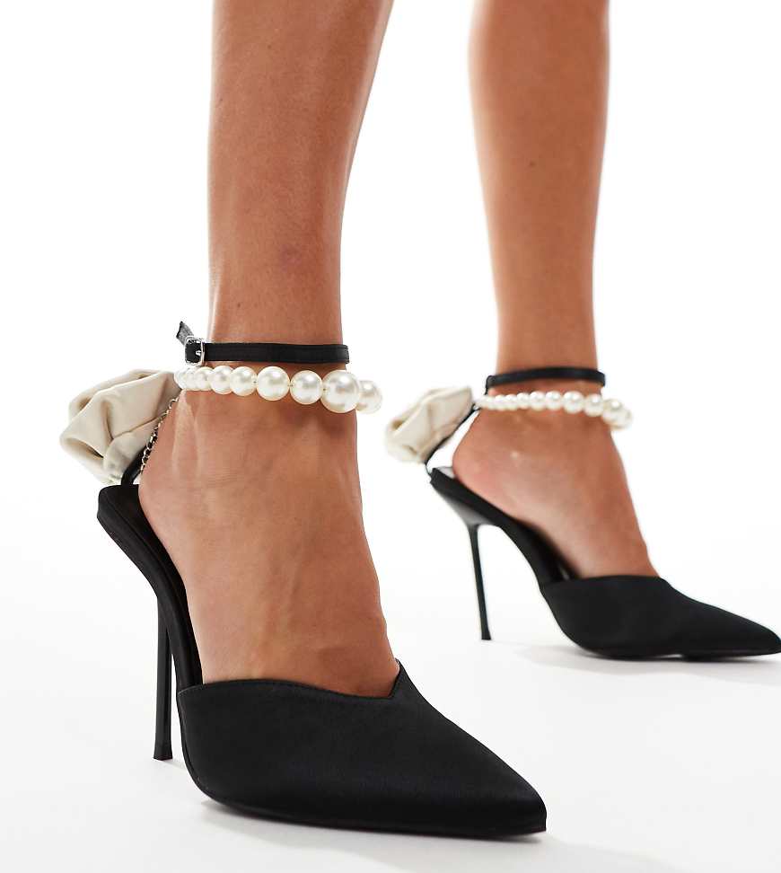 Public Desire - Wide Fit - Sariah - Spitze Pumps in Schwarz mit Perlen-Fesselriemen und Ansteckblume, weite Passform Public Desire - Wide Fit - Sariah - Spitze Pumps in Schwarz mit Perlen-Fesselriemen und Ansteckblume, weite Passform von Public Desire Wide Fit