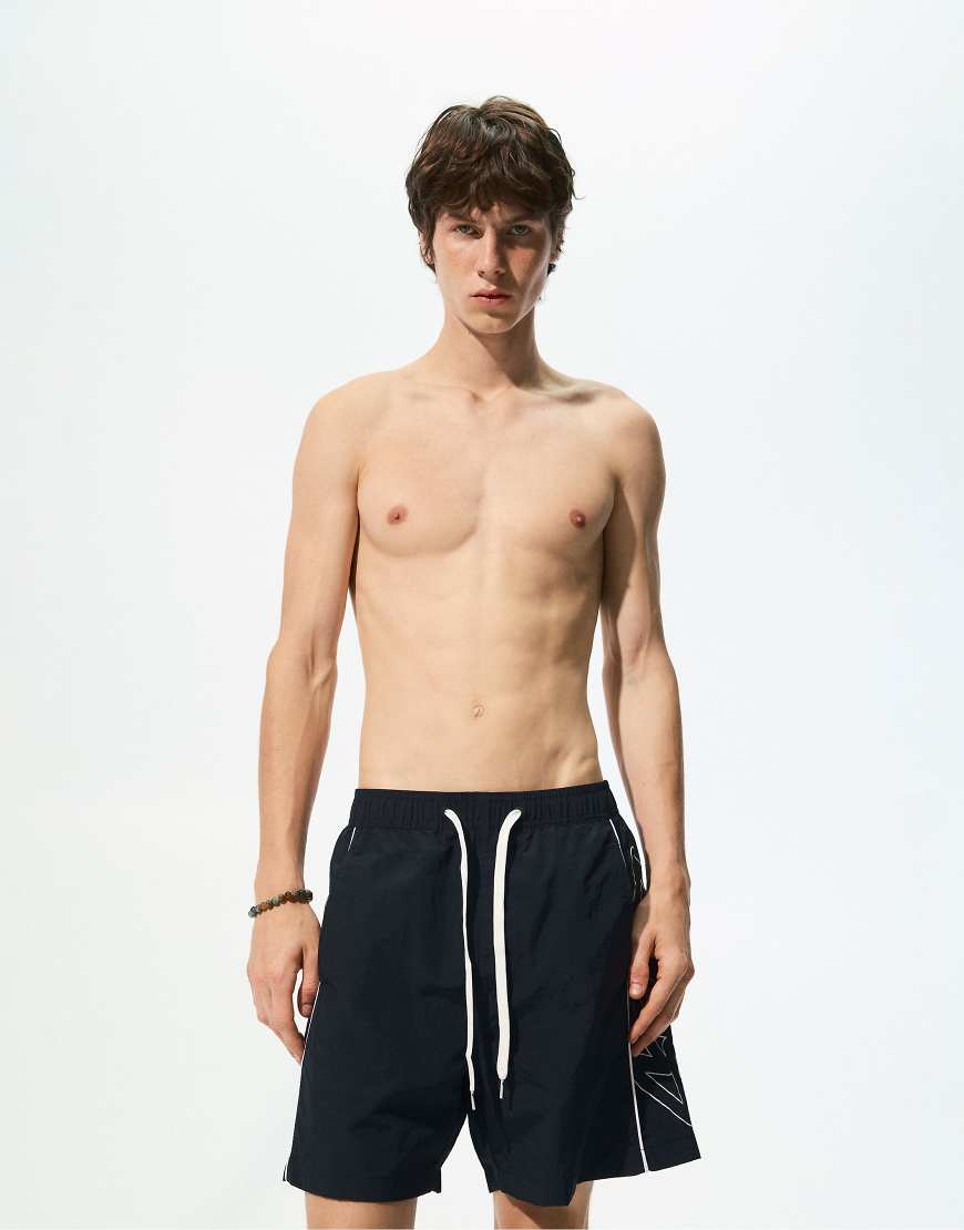Pull & Bear - Boardshorts in Schwarz mit seitlichem Streifen und „STWD"-Print Pull & Bear - Boardshorts in Schwarz mit seitlichem Streifen und „STWD"-Print von Pull & Bear