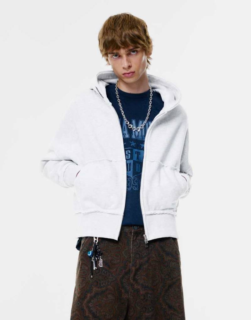 Pull & Bear - Kapuzenjacke in meliertem Grau mit „Stwd Studio"-Print von Pull & Bear