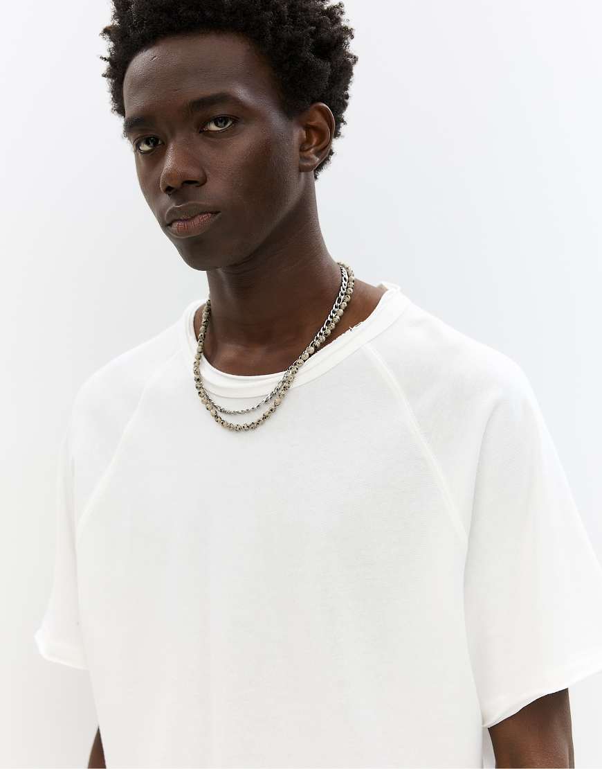 Pull & Bear - Kurzärmliges T-Shirt in Wollweiß mit Besätzen Pull & Bear - Kurzärmliges T-Shirt in Wollweiß mit Besätzen von Pull & Bear