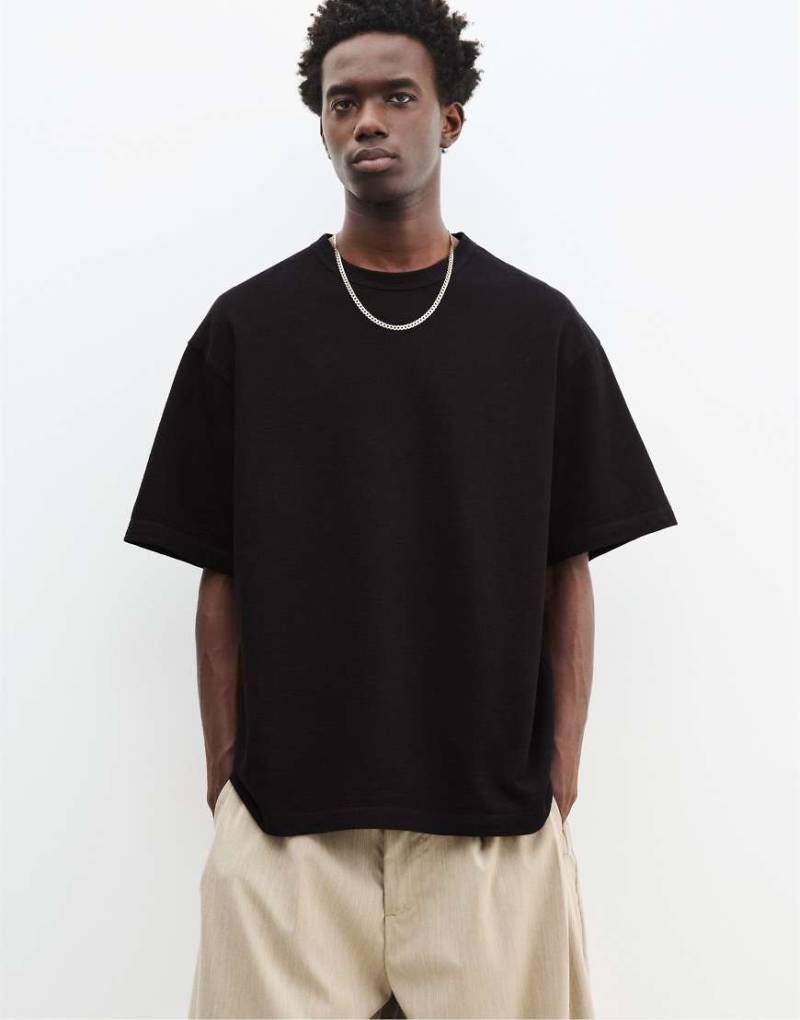 Pull & Bear - Strukturiertes, kurzärmliges T-Shirt in Schwarz Pull & Bear - Strukturiertes, kurzärmliges T-Shirt in Schwarz von Pull & Bear