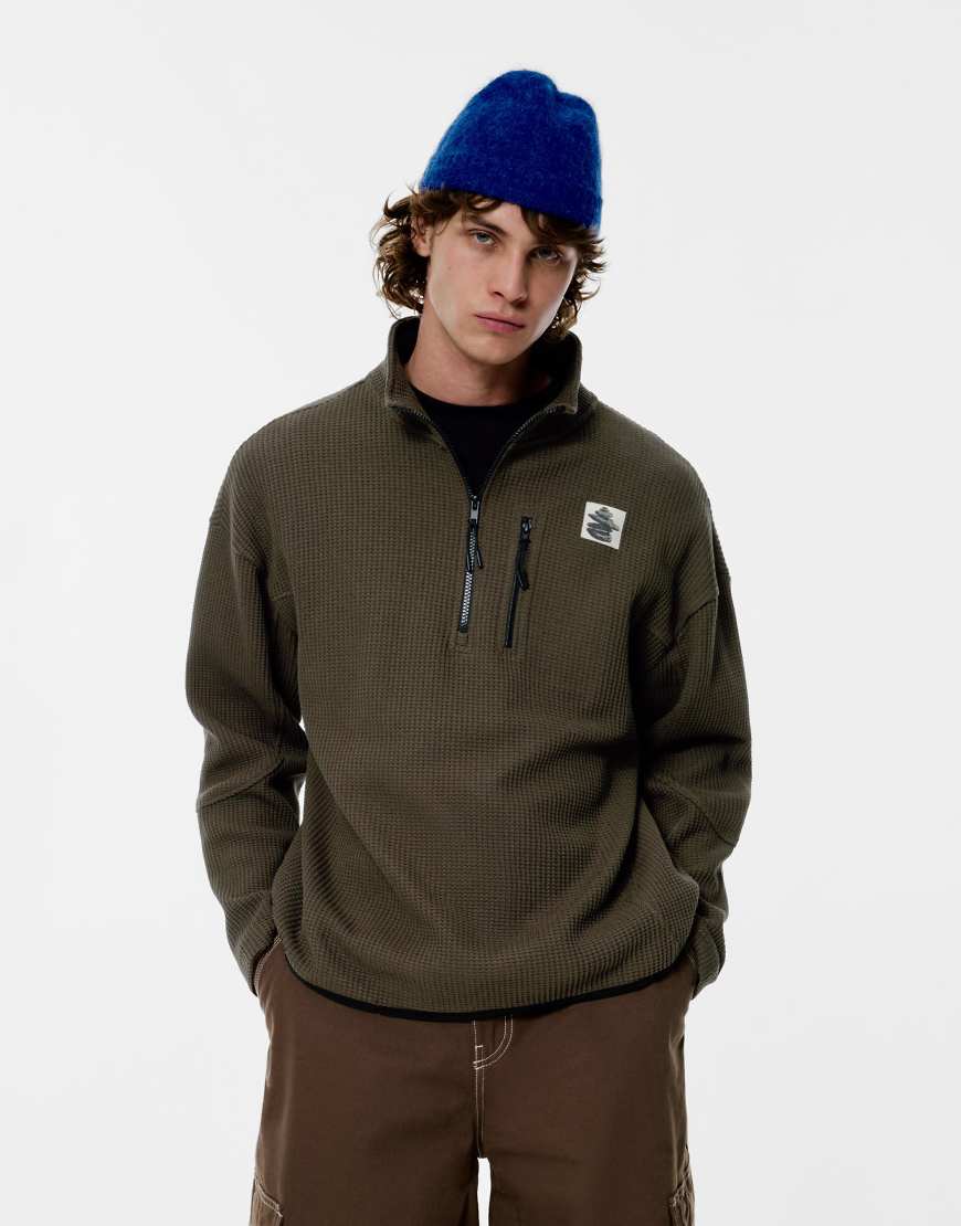 Pull & Bear - Sweatshirt in Grün mit kurzem Reißverschluss und Grafik von Pull & Bear