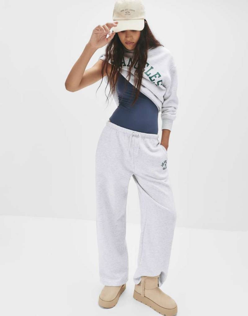 Pull & Bear - Trainingshose in meliertem Grau mit College-Prints von Pull & Bear