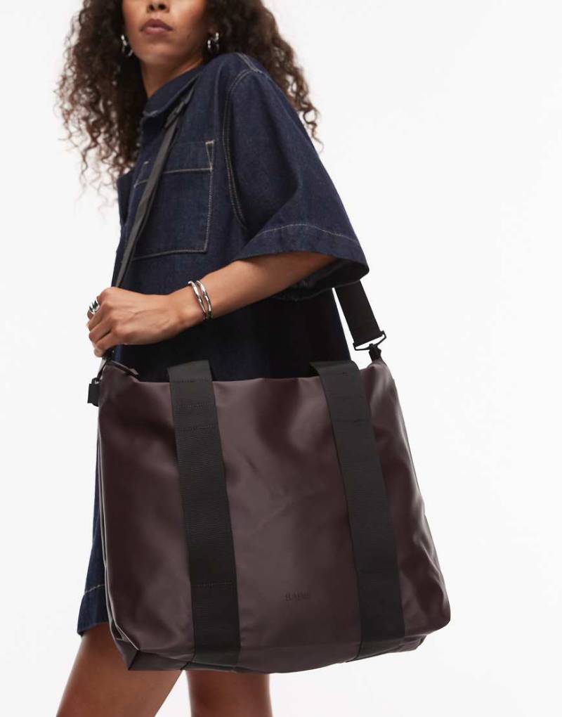 Rains - Kleine wasserdichte Tragetasche in Dunkelbraun von Rains