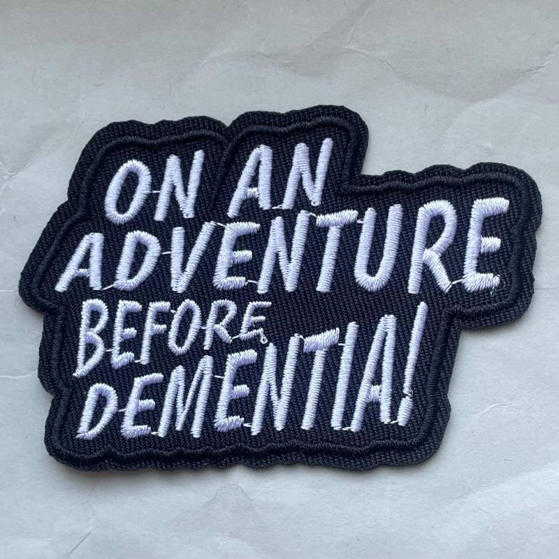 On An Adventure Before Dementia - Schwarzer Statement-Patch Mit Schwarzem Humor Für Freiheitsliebende, Rebellen Und Weltenbummlerinnen von RealFakeberlin