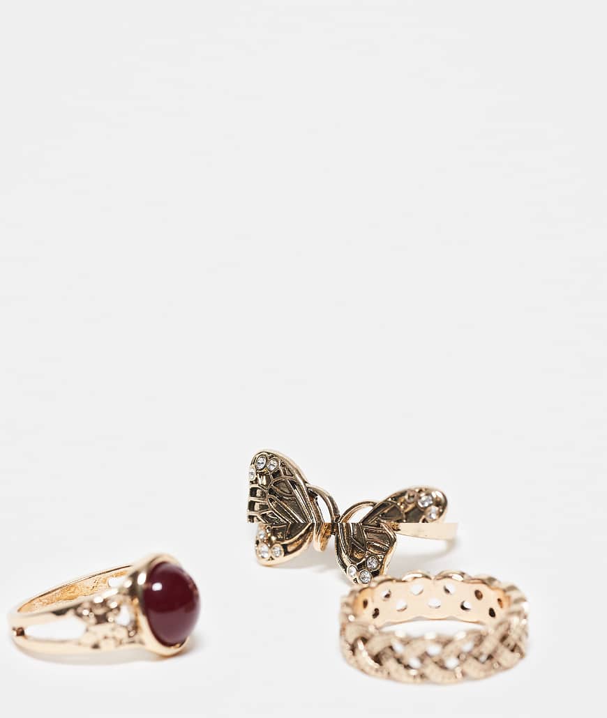 Reclaimed Vintage - 3er-Pack Ringe in Gold mit Schmetterling-Detail und rotem Kunststein-Goldfarben von Reclaimed Vintage