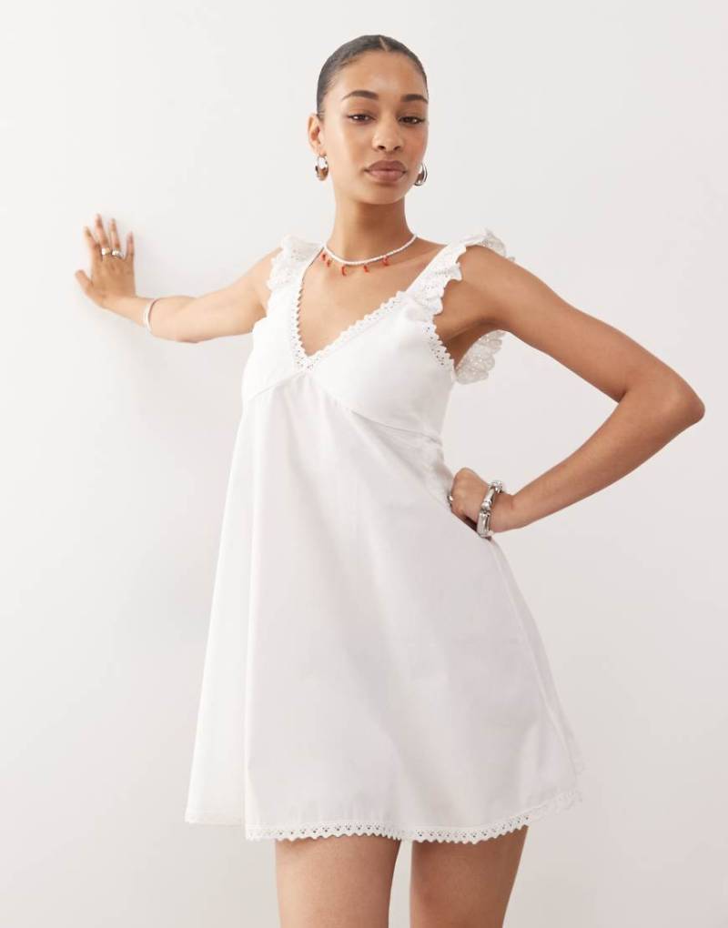 Reclaimed Vintage - Babydoll-Camisole-Minikleid aus Popeline in Cremeweiß mit Lochstickerei und Spitzenbesatz Reclaimed Vintage - Babydoll-Camisole-Minikleid aus Popeline in Cremeweiß mit Lochstickerei und Spitzenbesatz von Reclaimed Vintage