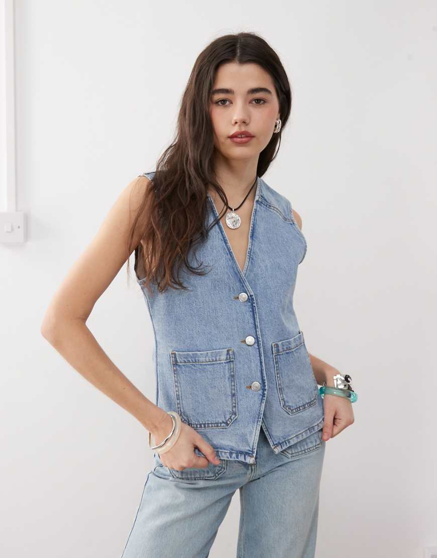 Reclaimed Vintage - Denim-Weste im 70er-Stil mit aufgesetzten Taschen in blauer Waschung, Kombiteil Reclaimed Vintage - Denim-Weste im 70er-Stil mit aufgesetzten Taschen in blauer Waschung, Kombiteil von Reclaimed Vintage